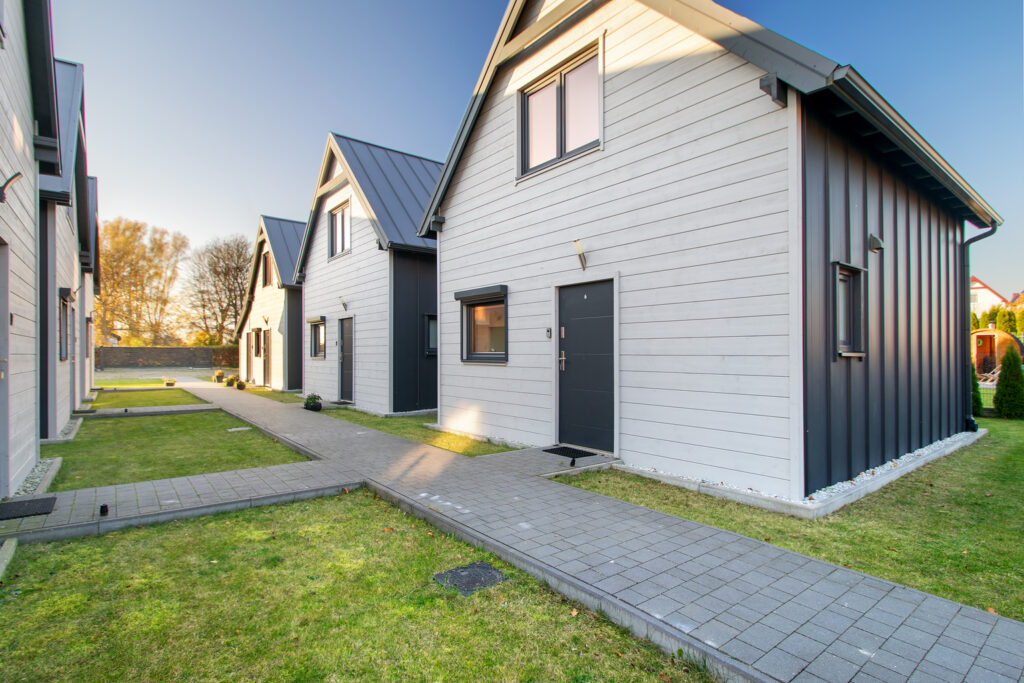 Nowoczesne domki letniskowe z zadbanym terenem i brukowaną ścieżką dla gości.